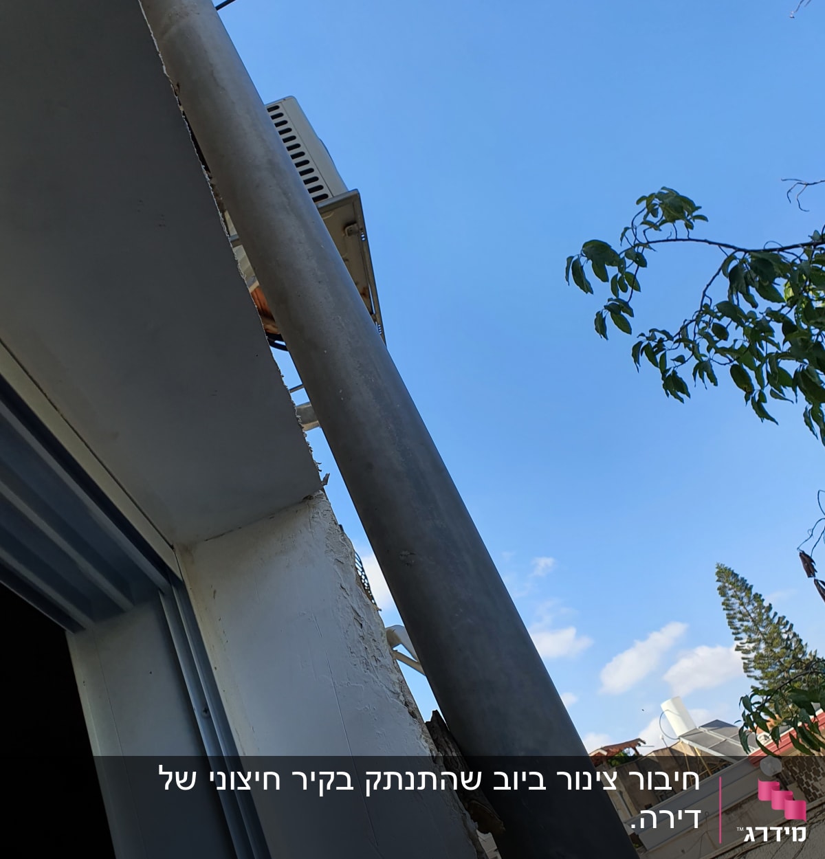 צינור מתכת מחובר לקיר חיצוני של מבנה